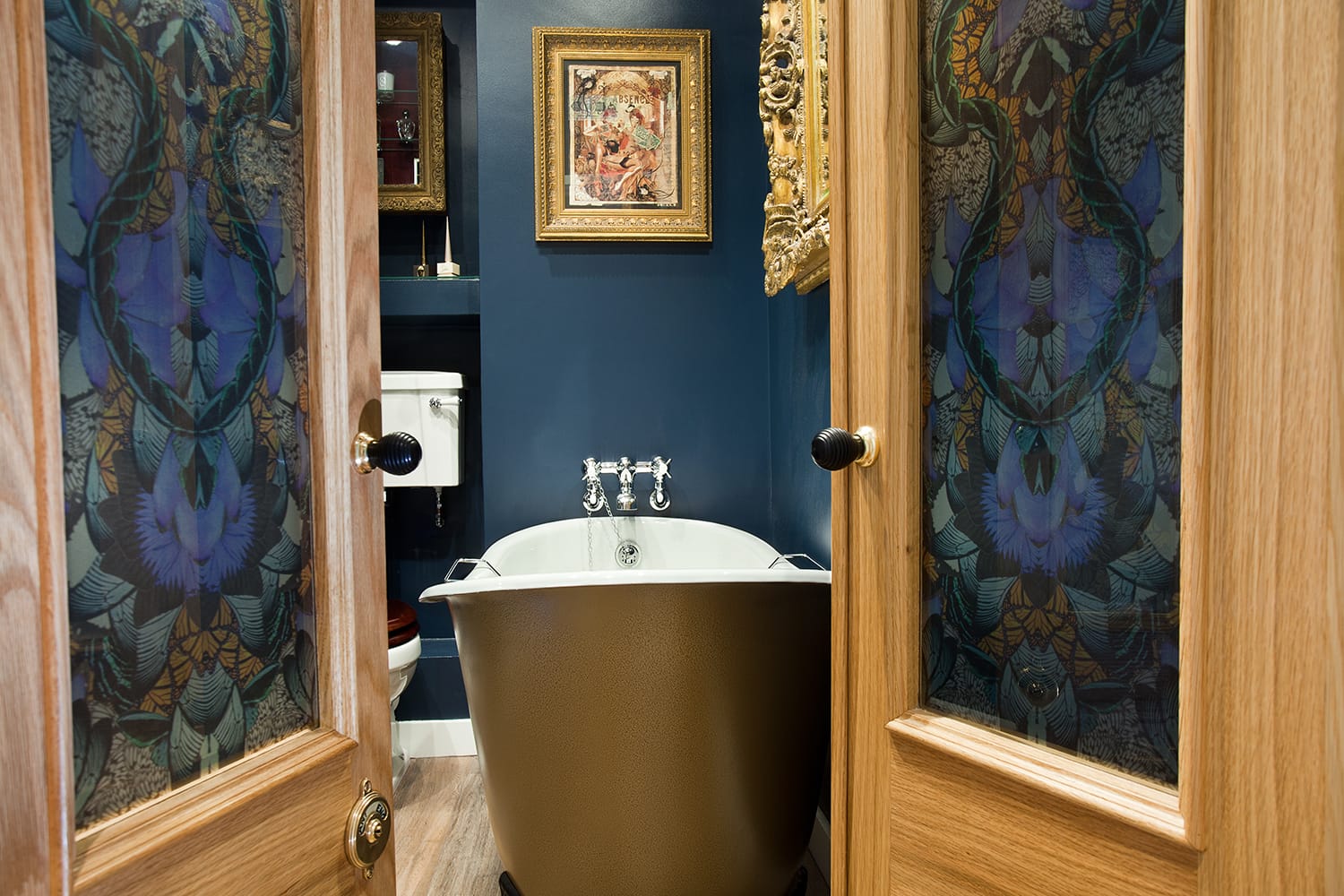 Image: Glamorous bathroom boudoir with rich blue walls and gold accents