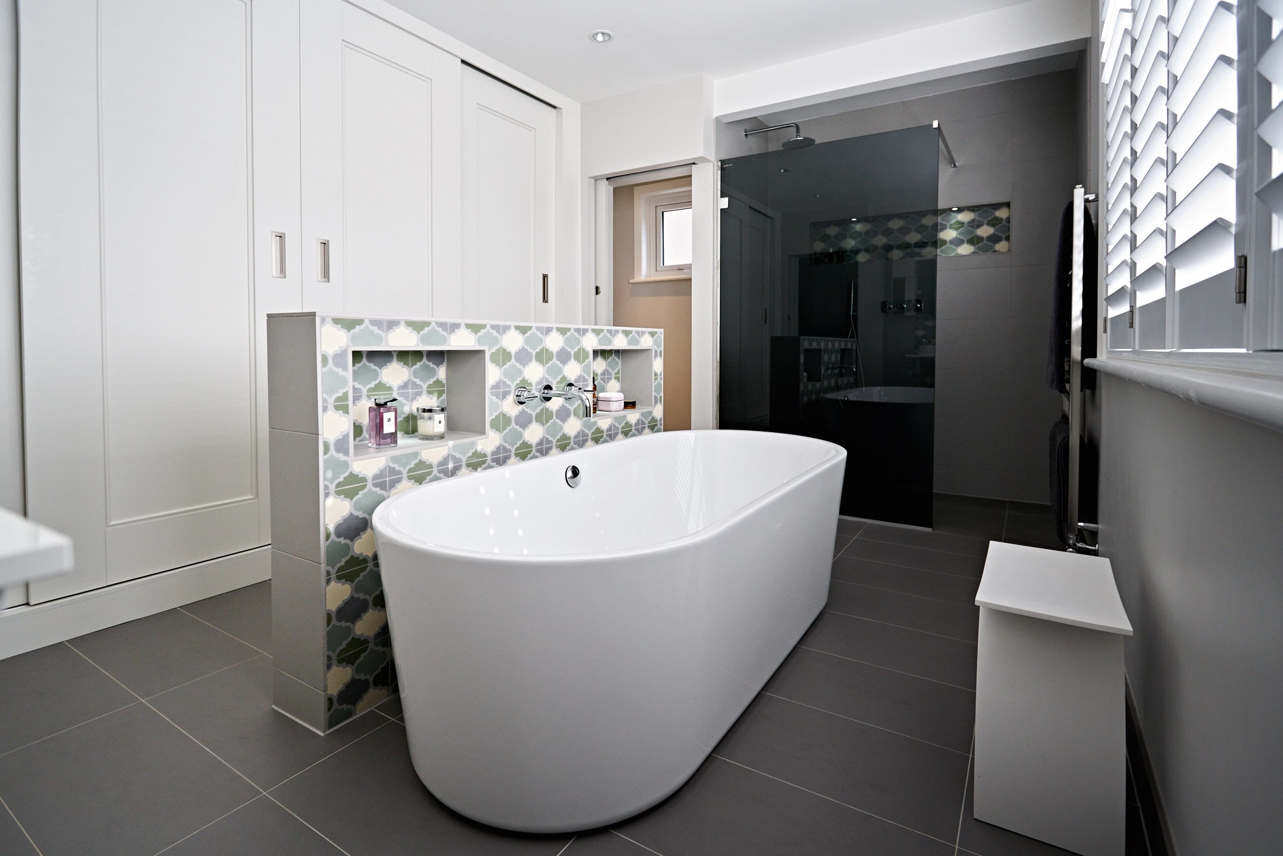 Image: Master ensuite with soft blue and green feature tiling and bespoke wardrobes