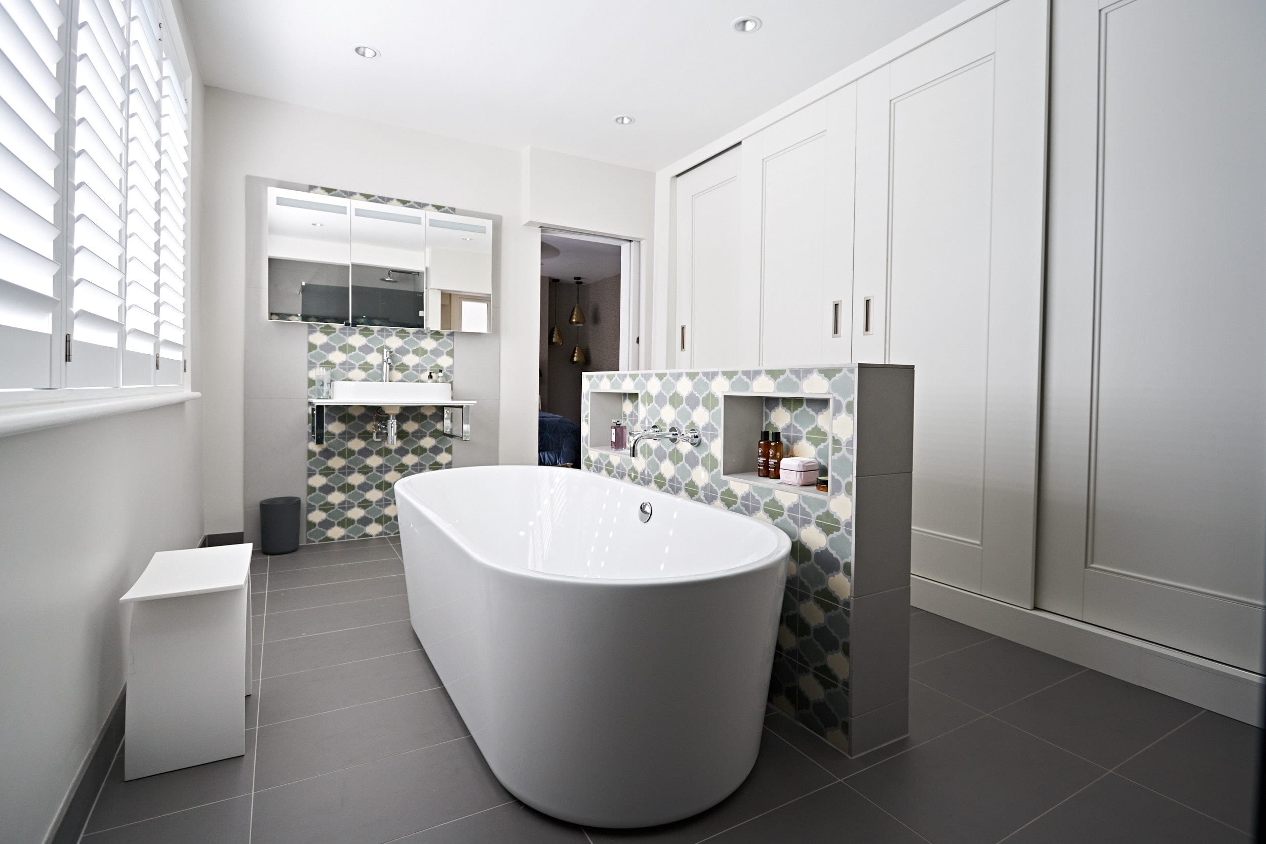 Image: Master ensuite with soft blue and green feature tiling and bespoke wardrobes