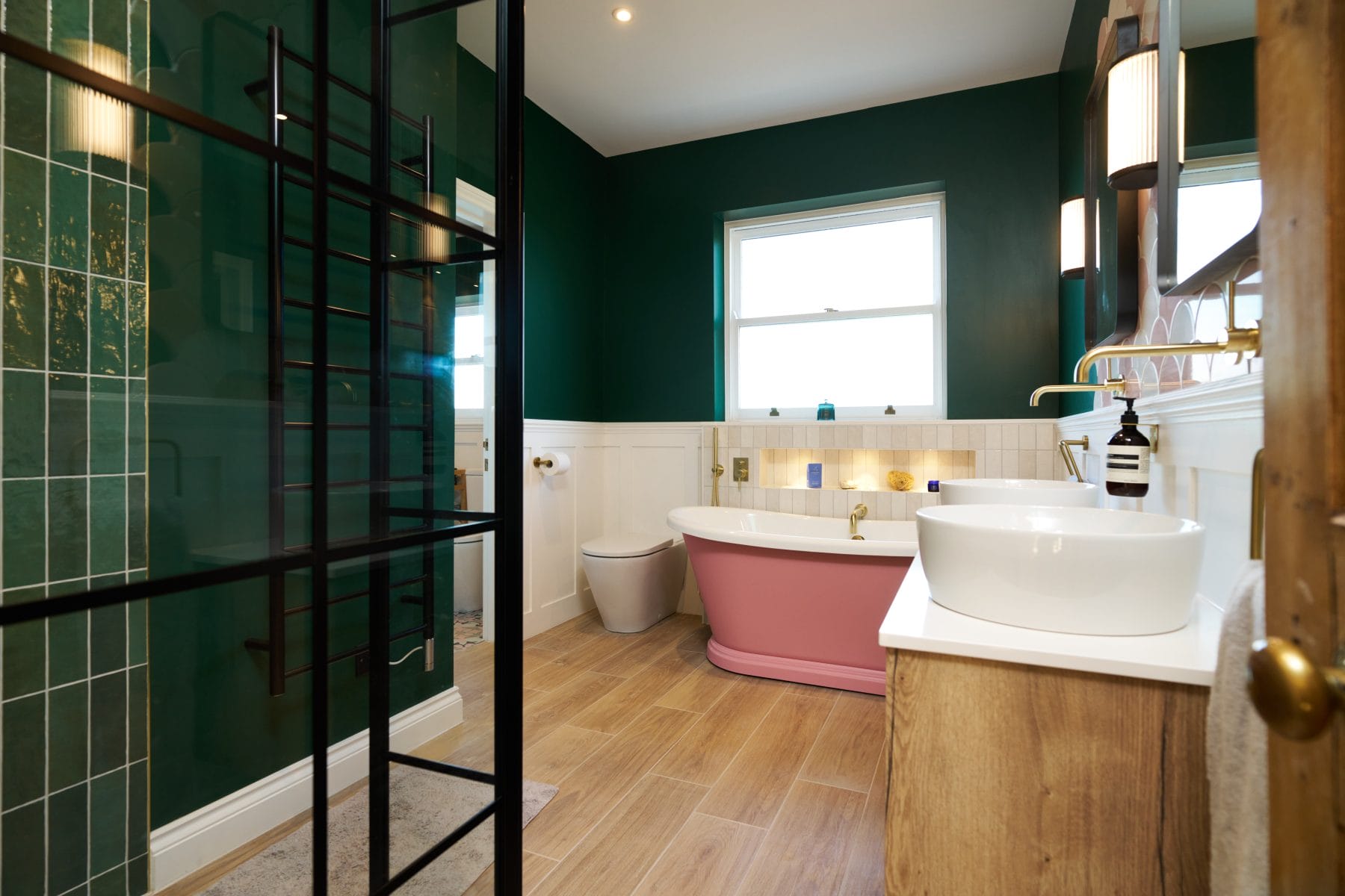 Pink painted bath Black shower enclosure Green painted walls Timber bathroom vanity in Balcombe