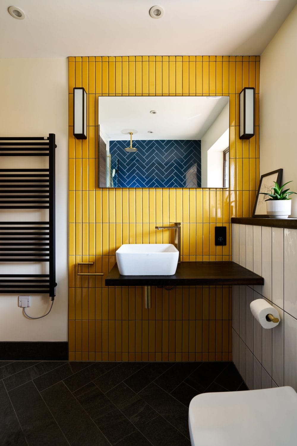 Yellow Feature Tiles with Black Wall Lights above Basin