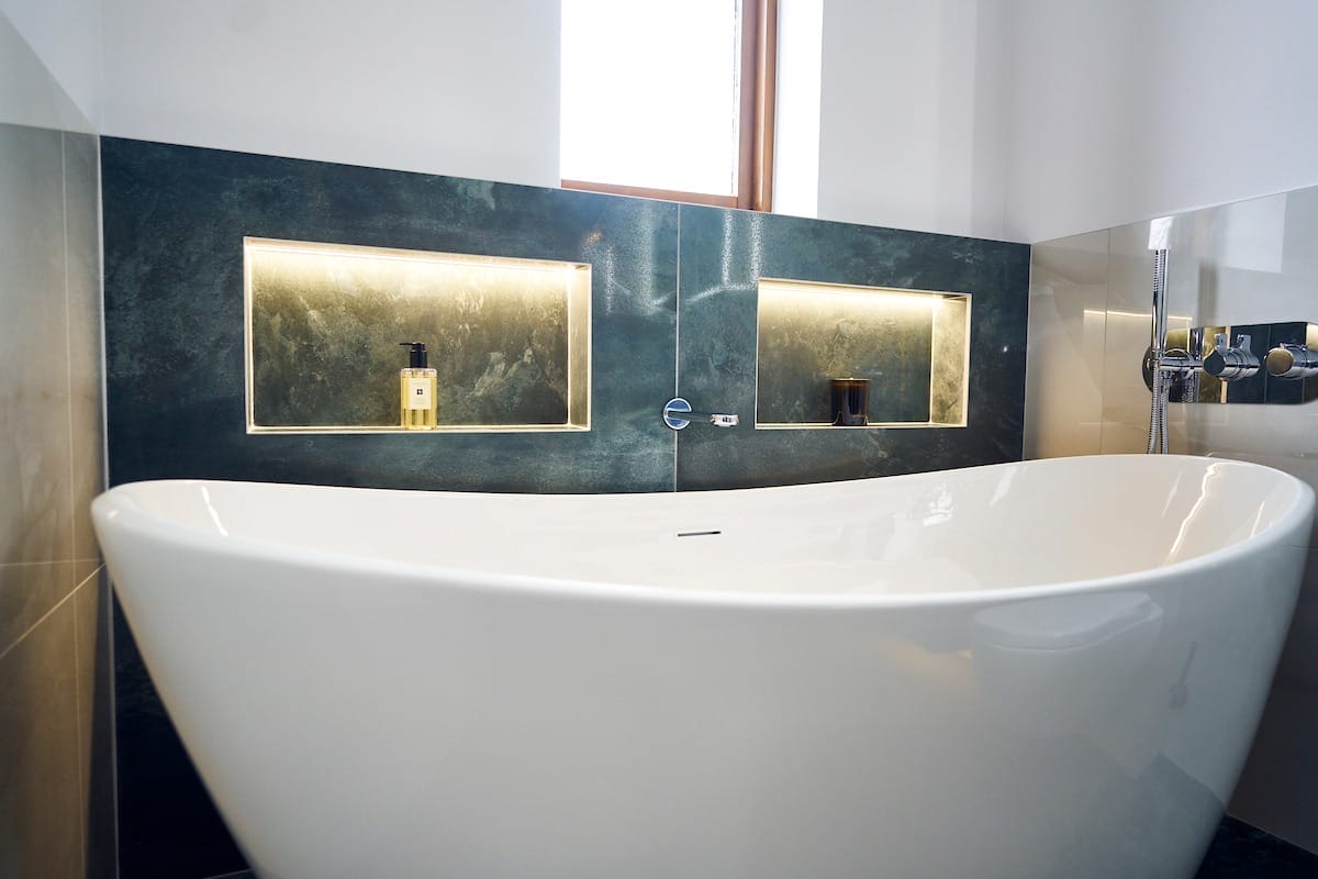 brushed steel bathroom tap detail over marble-effect surface