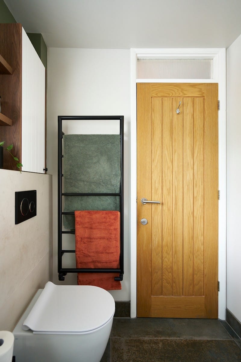 black towel rail with mitred corners and coral towel hanging on rail