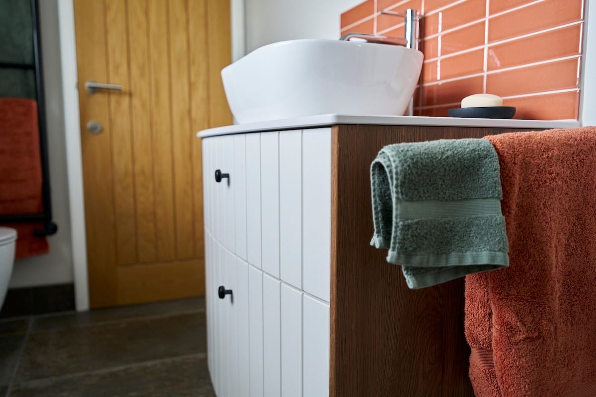 vanity unit with vertical grooves on the front in a painted finish with timber style sides