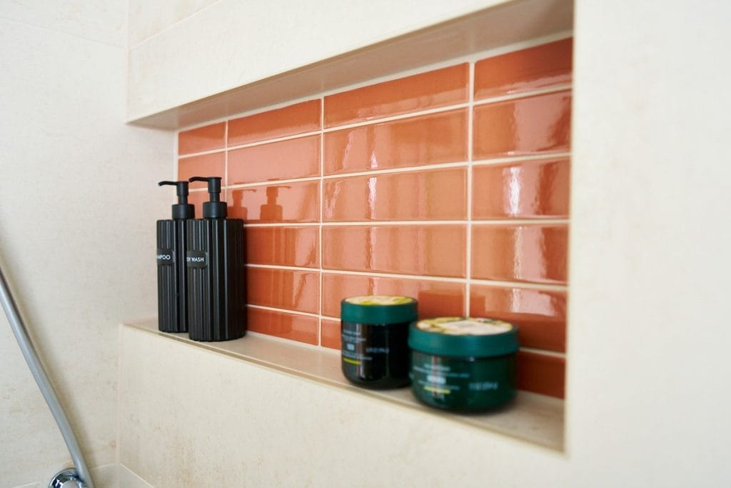 Bathroom recess with coral feature brick tiles and candles