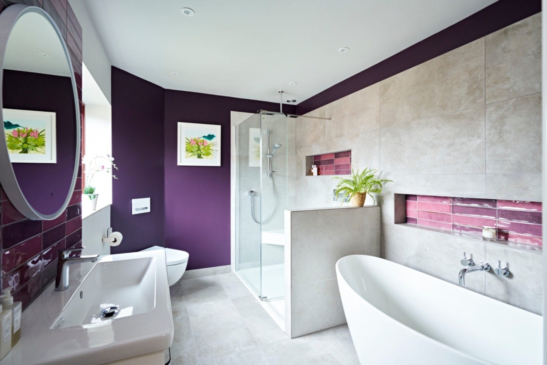 Luxury en-suite bathroom with purple feature walls and freestanding bath in Sussex