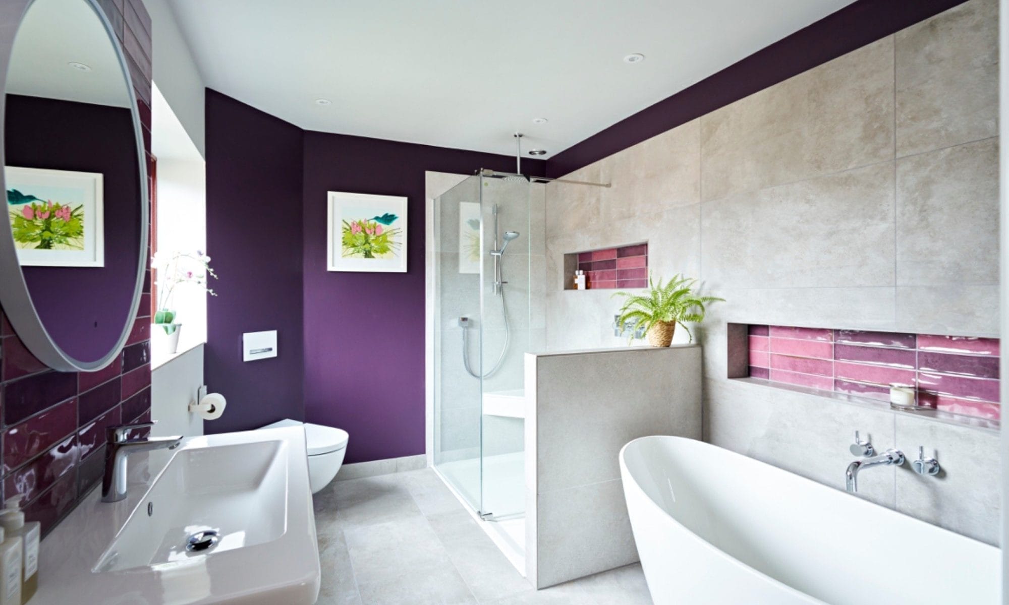 Luxury en-suite bathroom with purple feature walls and freestanding bath in Sussex